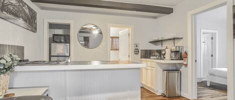 A modern kitchen with a central island, a dining area with a sofa, and a living room with a fireplace.