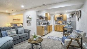 Uma sala de estar moderna com um sofá cinzento, uma mesa de centro e um espaço de jantar com uma mesa e cadeiras.