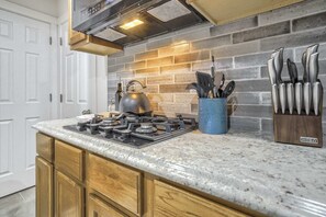 A kitchen with a gas stove, a kettle, and a knife block. - 1BD Suitewalking Distance From Red Rocks (Colorado Springs)