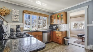 A kitchen with wooden cabinets, a granite countertop, and a dishwasher.