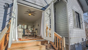 A wooden house with a front porch, a ceiling fan, and a staircase leading to the entrance. - 1bdlovely Cottagedogs Welcome!near Olympic Training Center (Colorado Springs)