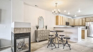 Une cuisine moderne dotée d’un îlot central, de meubles en bois et d’un four à micro-ondes encastré.