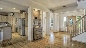 A spacious kitchen with wooden cabinets, a stainless steel refrigerator, and a wooden island.