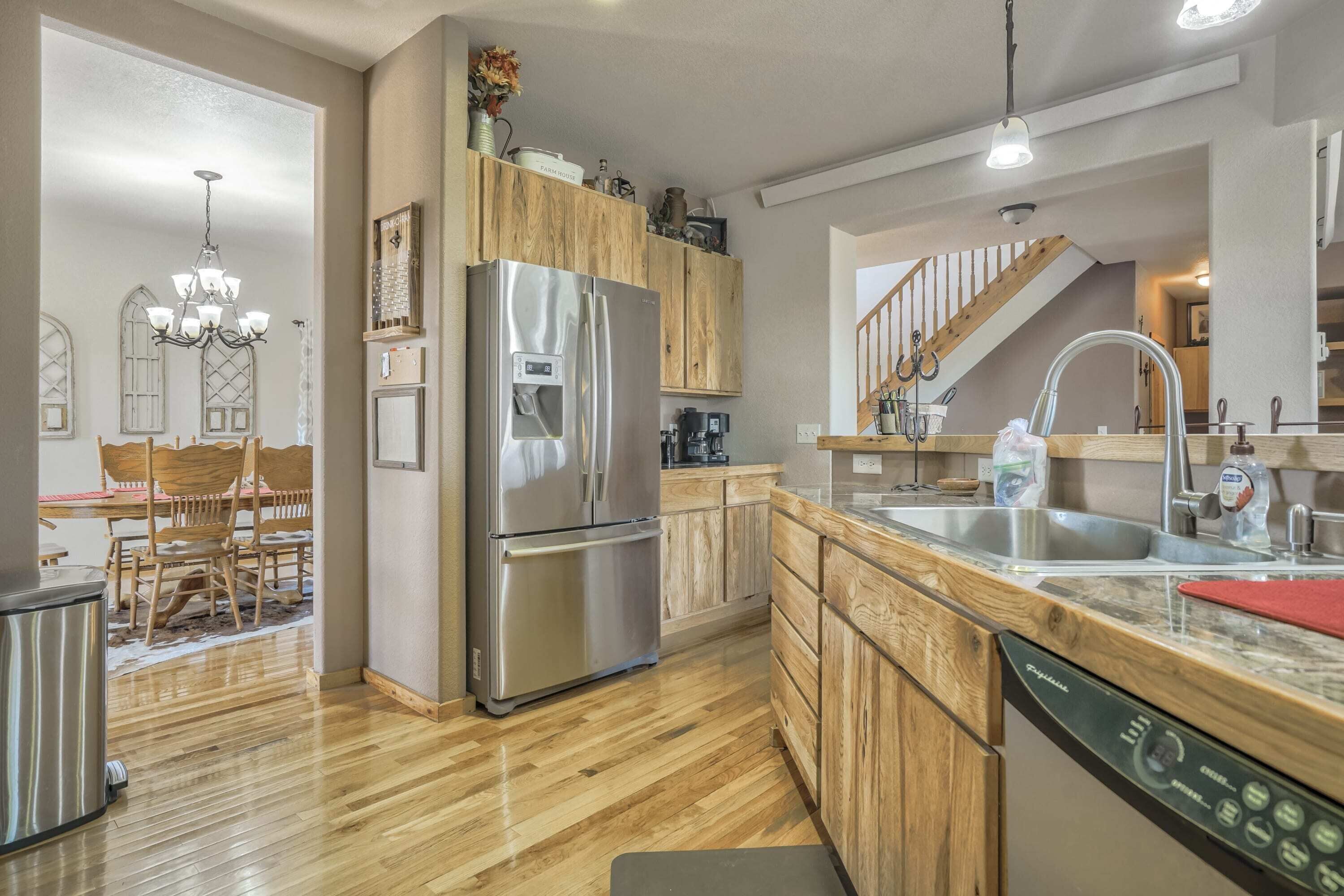A modern kitchen with wooden cabinets, stainless steel appliances, and a dishwasher.