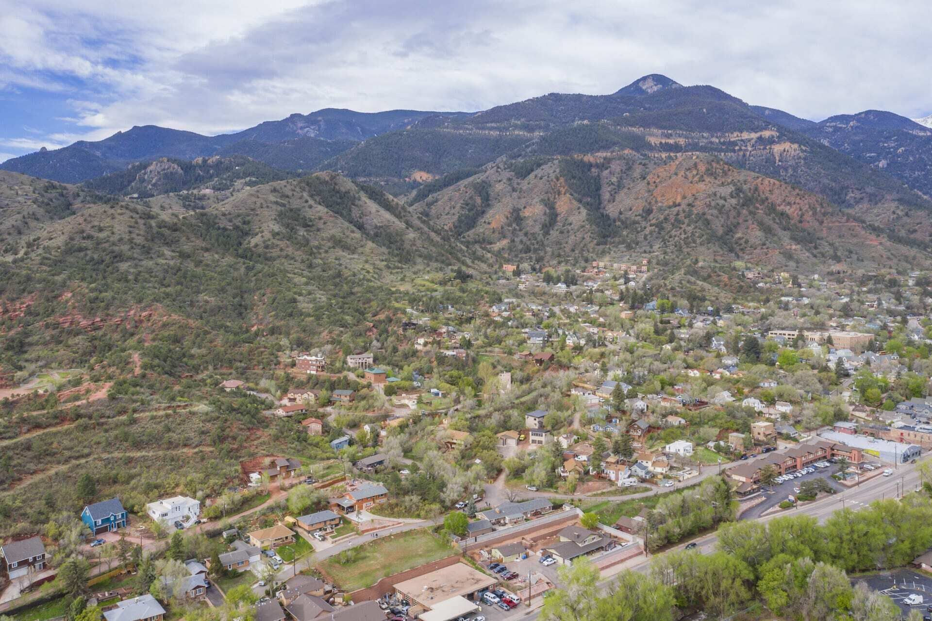 A town nestled in a valley with mountains in the background.