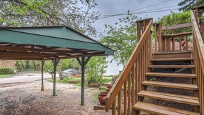 A covered outdoor area with a wooden staircase leading to a higher level.