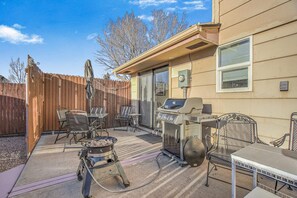 A backyard with a barbecue grill, outdoor seating, and a wooden fence. - 2bdcentrally Locatedclose to Shops & Restaurants! (Colorado Springs)