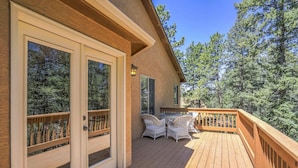 A wooden deck with outdoor furniture, large windows, and a view of trees. - 6bdfamily Mountain Getawayhot Tubminutes to Pikes Peak and Charis College (Woodland Park)