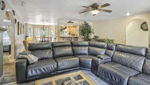 A living room with a large leather sectional sofa, a ceiling fan, and a dining area with a kitchen in the background. - 6bdfamily Mountain Getawayhot Tubminutes to Pikes Peak and Charis College (Woodland Park)