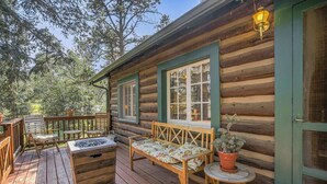 A log cabin with a wooden deck, a bench, a small table, and a potted plant. - Wine Gazebopikes Peak Mountain Log Cabin for 2 (Cascade)