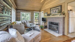 A log cabin interior with a fireplace, a sofa, and a television. - Wine Gazebopikes Peak Mountain Log Cabin for 2 (Cascade)
