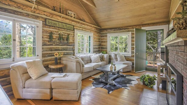 A log cabin interior with a sofa set, a coffee table, and a fireplace. - Wine Gazebopikes Peak Mountain Log Cabin for 2 (Cascade)