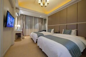 A hotel room with two beds, a TV, a desk, and a chair. - Xi Er Dun Hotel (Shuyang)