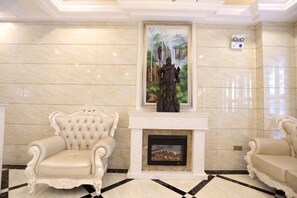 A room with a fireplace, two armchairs, a painting, and a tiled floor. - Xi Er Dun Hotel (Shuyang)