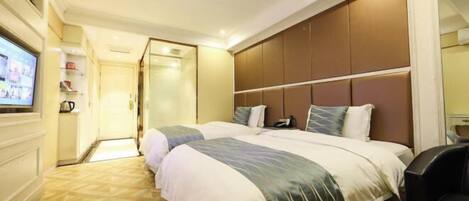 Quarto de hotel com duas camas, televisão e minibar.