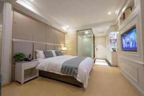 A hotel room with a large bed, a bedside table with a lamp, a TV mounted on the wall, and a sliding door leading to a bathroom. - Xi Er Dun Hotel (Shuyang)