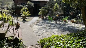 Un patio empedrado con plantas en macetas, un edificio de ladrillo y una escalera de metal.