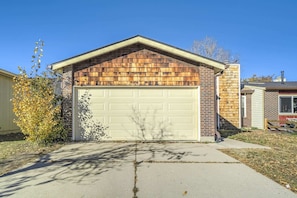 A single-story house with a garage, brick exterior, and a sloped roof.