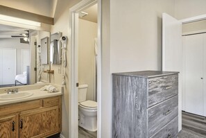 A bathroom with a wooden vanity, a white sink, and a toilet.