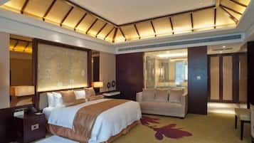 Een hotelkamer met een groot bed, een bank, een bureau en een spiegel.