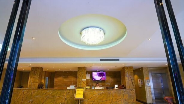 A hotel reception area with a marble counter, a television screen, and an elevator. - Zhongya Hotel (Nanning)