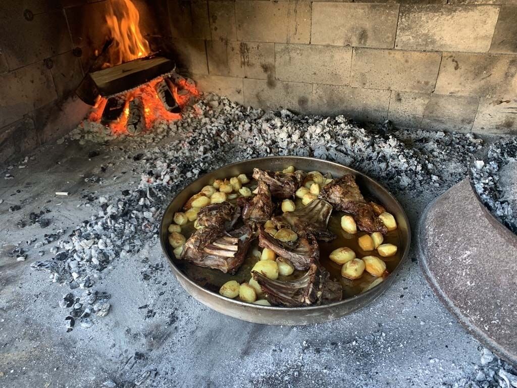 A grill with meat and potatoes.