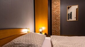 A hotel room with two beds, a wooden headboard, a brick wall, and a mirror on the wall. - Apartment in Lopar with Balcony, Air condition, WIFI (4739-4) (Lopar)