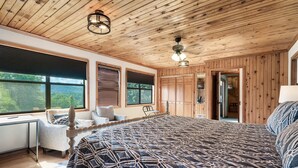 A bedroom with a large bed, wooden ceiling, and a view of the outdoors. - True Family Getaway! Awesome Views | Easy Access (Townsend)