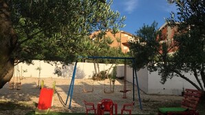 A playground with swings and a small table with chairs.