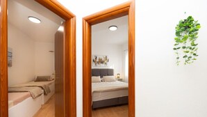 Une chambre à coucher avec un lit, une table de chevet et une petite plante accrochée au mur.