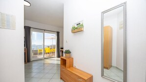 Une chambre d’hôtel avec une console en bois, un miroir et une petite plante accrochée au mur.