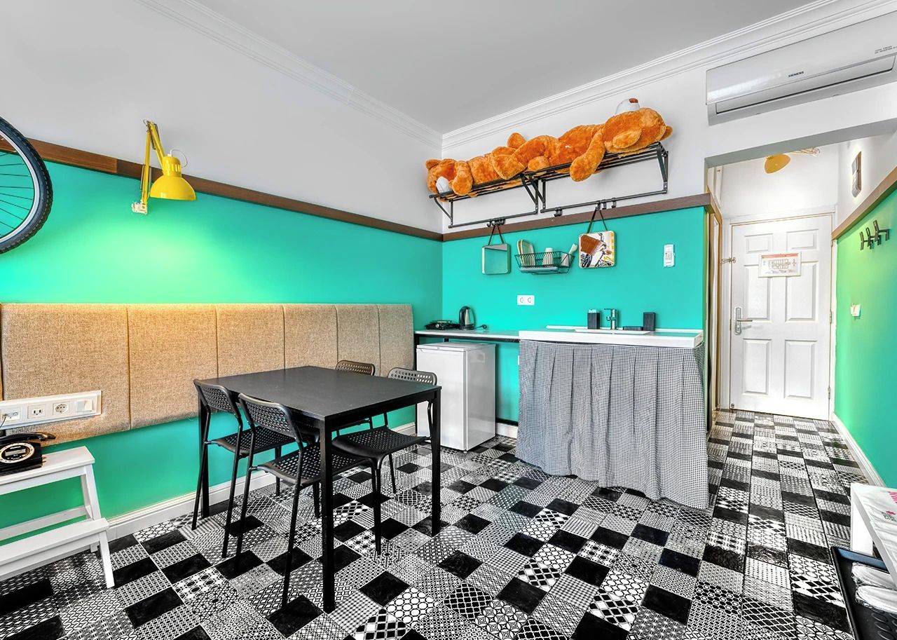 A compact kitchen with a dining area, a small refrigerator, and a table with chairs.