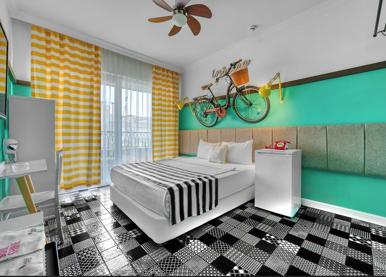 A modern bedroom with a bed, a bedside table, a mirror, and a bicycle wall decoration.