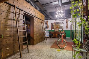 A room with wooden lockers, a bicycle, and a chandelier. - Anjeliq Downtown Hotel (Alanya)
