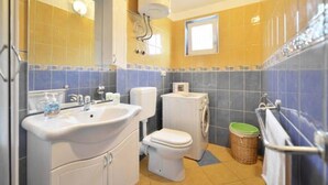 A bathroom with a sink, toilet, and washing machine.