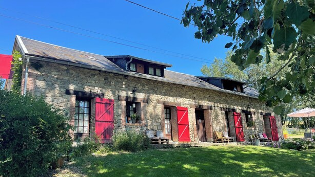 A stone building with red shutters, a grassy yard, and a clear blue sky. - Maison d'hôtes Ourdeaux et gîte Chez Rouchon (Alleyrat)