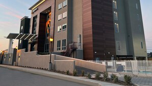 A modern hotel with a flat roof, multiple windows, and a gated entrance. - La Quinta Inn & Suites by Wyndham Galveston North at I-45 (Galveston)
