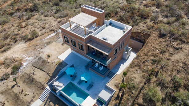 A modern two-story house with a rooftop terrace, a swimming pool, and a patio area.