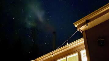 A house with a large window, a chimney, and a string of lights.