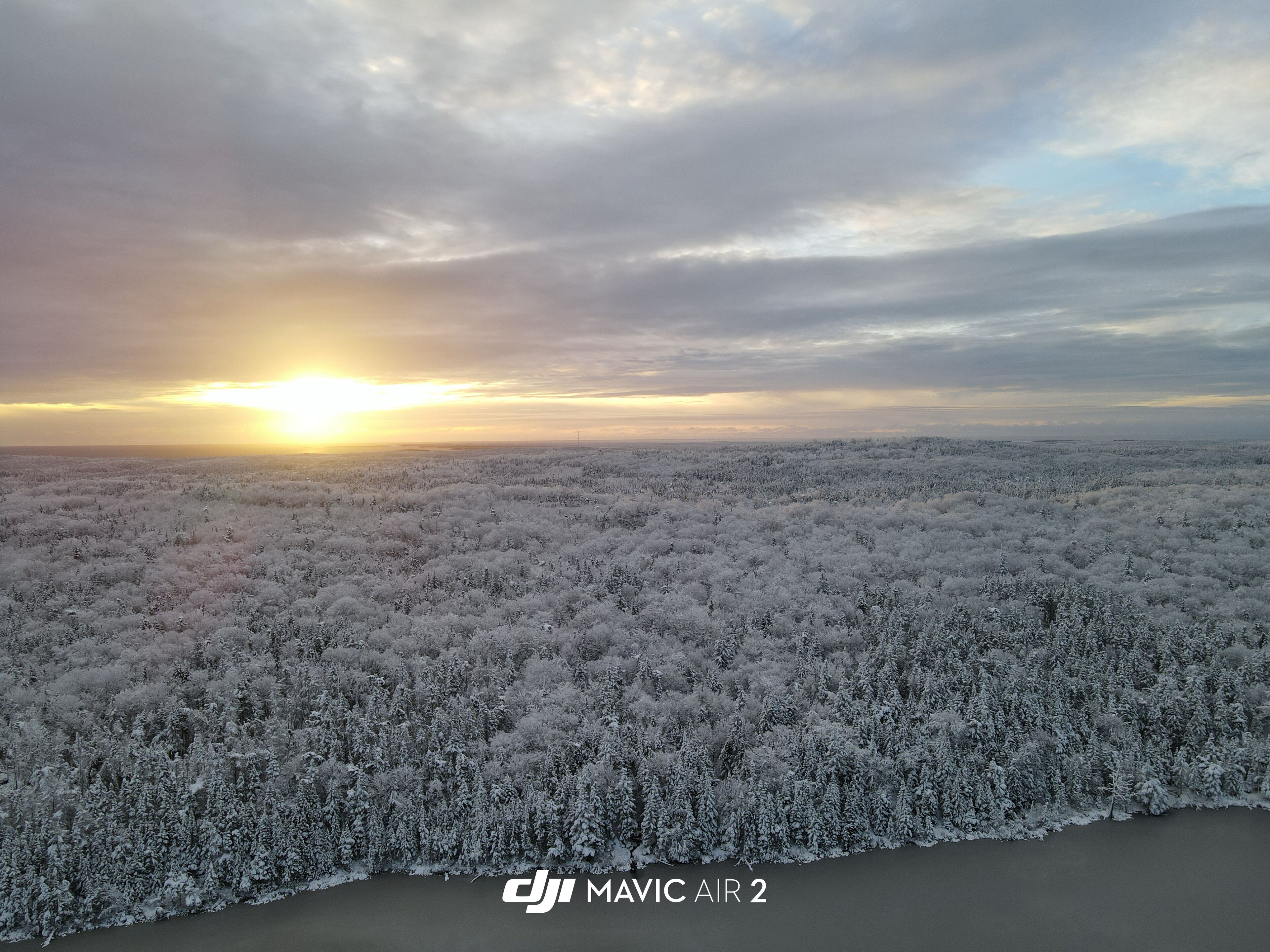 Uma vasta paisagem coberta de neve, com um pôr do sol ao fundo.