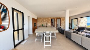 A modern interior with a dining area, kitchen, and seating space.