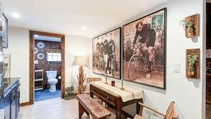 A room with a wooden bench, a table, and a wall-mounted lamp. - Suite 4: Outpost · Gorgeous Farm Carriage House Loft (Berryville)