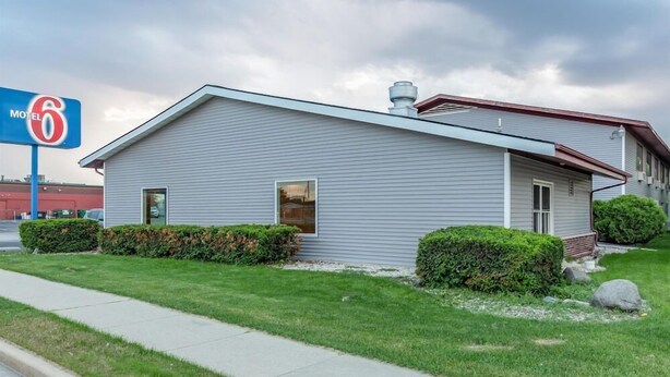 A motel with a single-story structure, a visible entrance, and a clear sky. - Motel6 Fond Du Lac, WI (Fond du Lac)