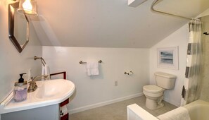 Bathtub, hair dryer, towels, toilet paper