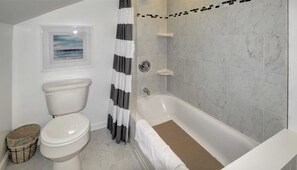 Bathtub, hair dryer, towels, toilet paper