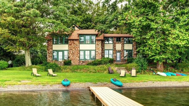 A lakeside house with a dock, two kayaks, and two lounge chairs. - Level Lakefront on Owasco Lake! Sleeps 14! (Auburn)