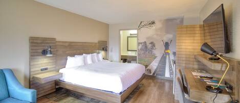 A bedroom with a bed, bedside tables, a desk, and a chair.