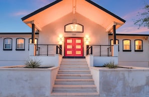 A modern building with a red door, numbered 2308, and a staircase leading to the entrance. - Lake Front Home with Pool, Dock, Views, Sports Court, & Beautiful Sunsets! (Lago Vista)