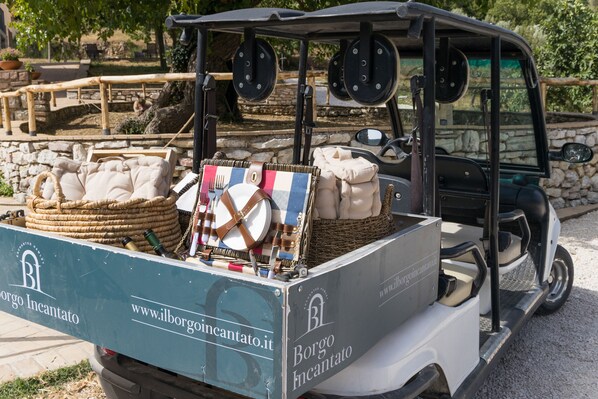 Un vehículo antiguo con una cesta de mimbre y bolsas en la parte trasera, con la marca 'Borgo Incantato'.