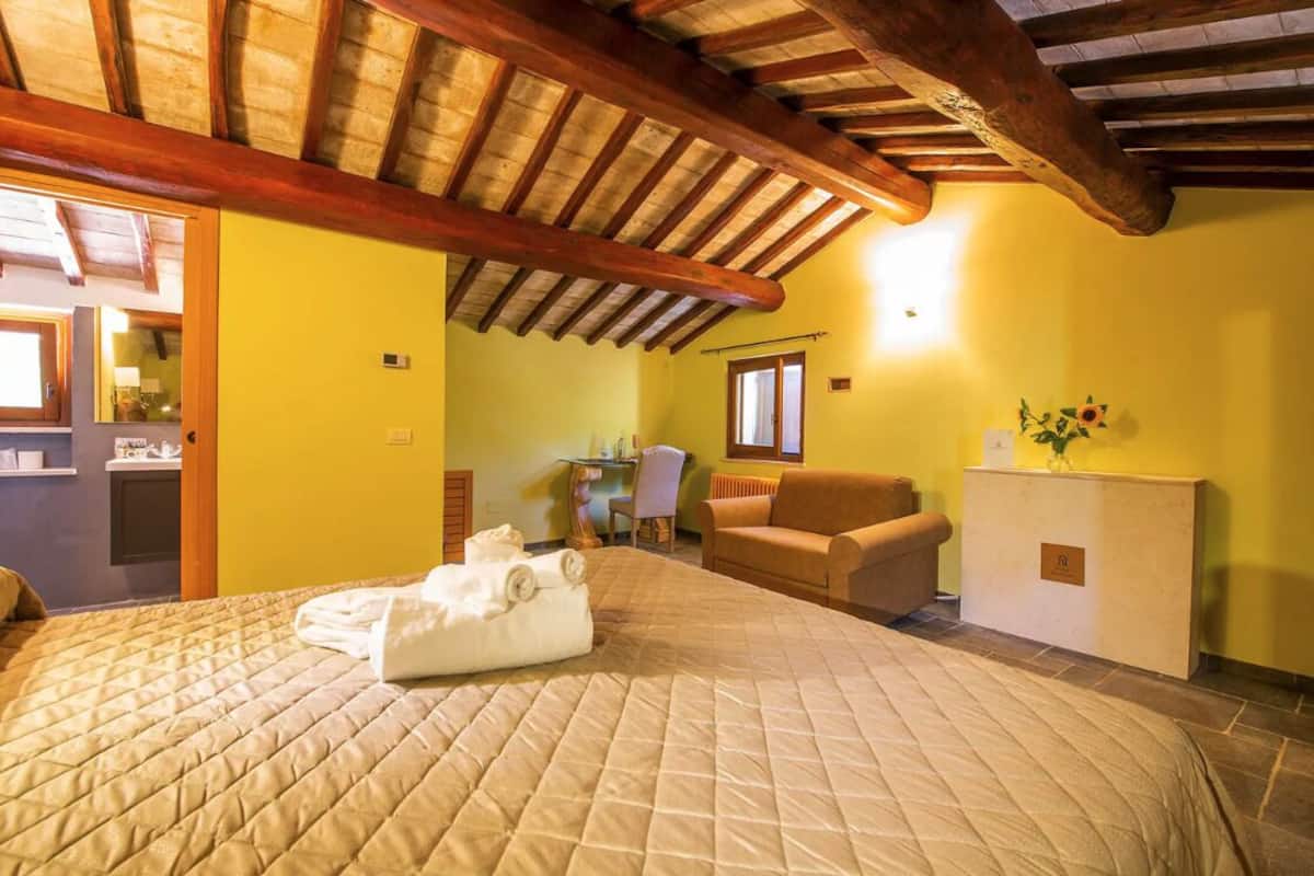 A hotel room with a bed, a desk, a chair, and a small cabinet.